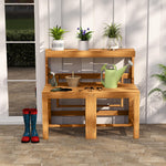 Wooden gardening bench with plants, tools, and boots in a garden setting.